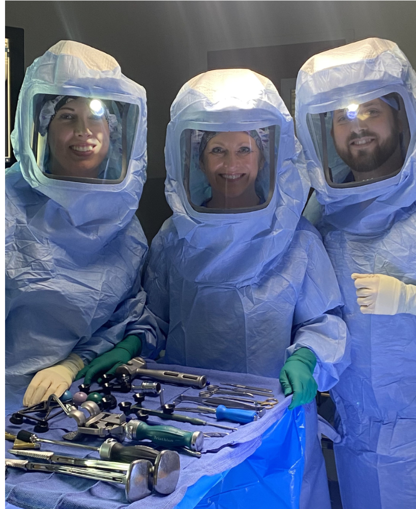 3 surgical team members preparing for procedure.
